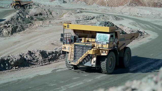 Loaded truck is driving along the copper, gold mine open pit deposit, slow motion