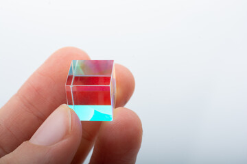 Optical glass cube in hand  Light dispersion,spectrum. Physics optics ray refractions