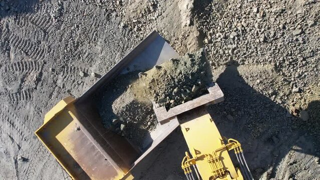 excavator loading crushed stone into a dump truck in a crushed stone quarry, slow motion