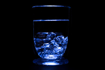 Thirst-quenching water or alcohol in a beautiful light on a black background