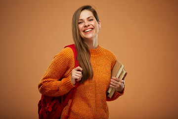 Happy laughing student woman wearing casual oversize sweater standing with book and red backpack. Isolated young female person portrait.