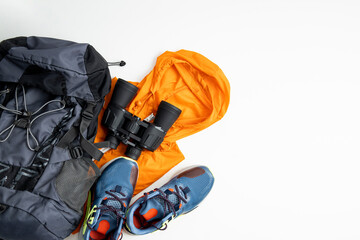 Binoculars, tourist things, shoes on a white background. Top view, flat lay