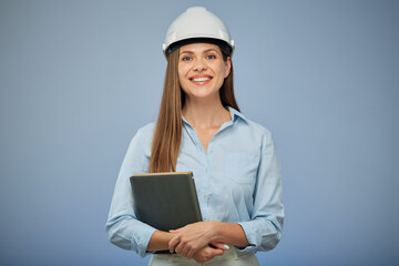 Woman architect holding book standing against blue background.