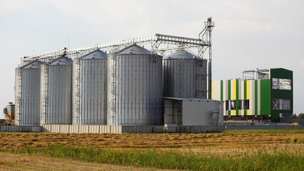 Fototapeta na wymiar Modern cereal dryer tanks on the farm . Agricultural business investments