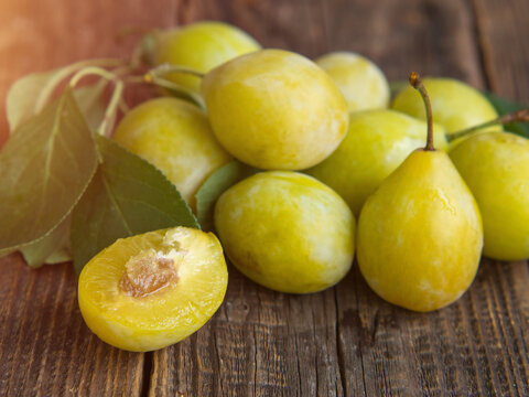 Fresh yellow plum closeup, yellow plum in on a wooden table .rustic background