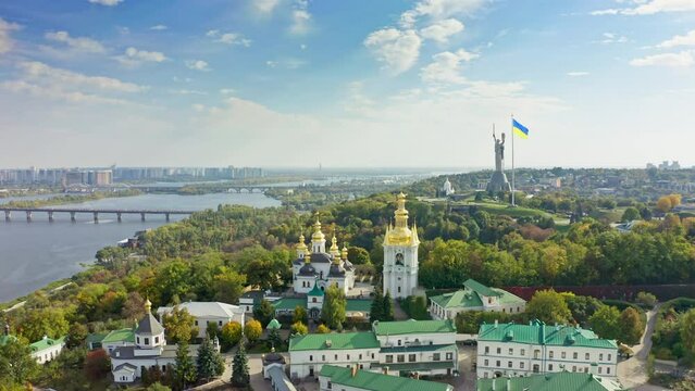 Aerial of Kyiv in summer. Churches, Motherland monument and Ukraine flag