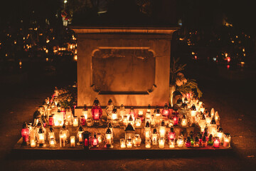 lit candles (lanterns) in the cemetery decorating graves during the Polish All Saints Day on November 1. Evening. Night. Blurred background. All Souls' Day.