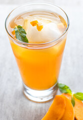 cup of tea passion fruit and mango with lemon and a mint leaf.