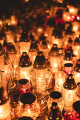 lit candles (lanterns) in the cemetery decorating graves during the Polish All Saints Day on November 1. Evening. Night. Blurred background. All Souls' Day.