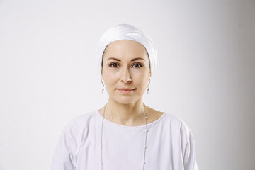 Portrait of a girl in a hijab in white clothes against a white background