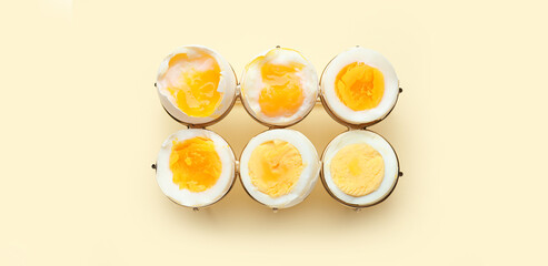 Different stages of boiling eggs on beige background, top view