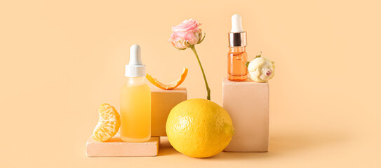 Composition with bottles of essential oil, rose flowers and citrus fruits on beige background