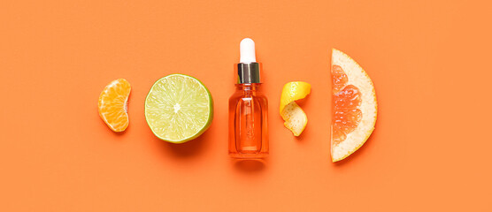 Composition with bottle of citrus essential oil and fruits on orange background