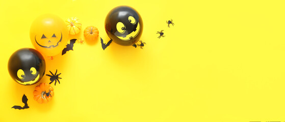 Composition with Halloween decor and balloons on yellow background with space for text, top view