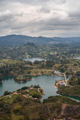 Fototapeta na wymiar Aerial shot of the Guatape town in Columbia with mountains and clouded sky in the background