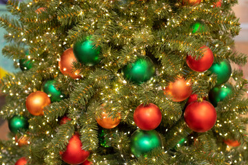 Obraz na płótnie Canvas Red and green Christmas balls on a spruce branch close-up, festive New Year card background