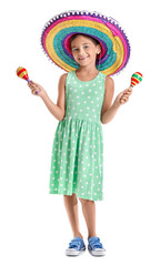 Happy little Mexican girl in sombrero hat with maracas on white background