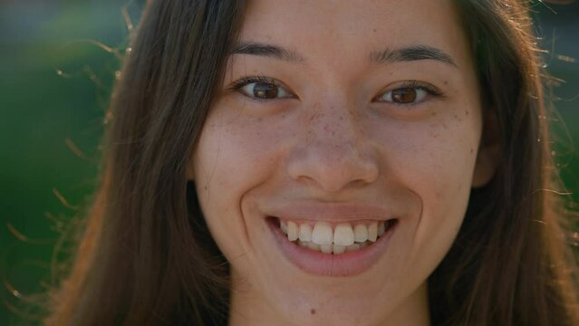 Portrait of the beautiful asian woman with freckles looking at the camera. Young cute lady looking straight to the camera. Close up.People concept