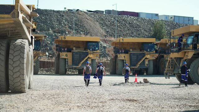Driviers prepare to drive dumper trucks mining equipment in gold mine pit excavation quarry