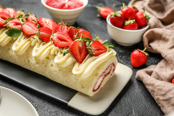 Plate with tasty strawberry roll cake on dark background, closeup