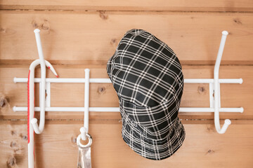 Country rustic textile hat hanging on a hook, hangers in a hallway in a wooden house
