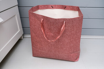 Empty paper shopping bag on the floor with no goods and clothes, saving money and deficit concept