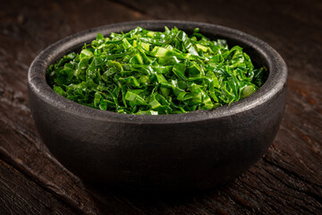 Bowl with chopped green cabbage sautéed in olive oil and garlic.