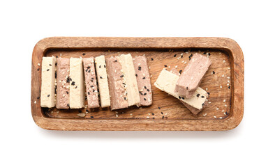 Wooden board with pieces of delicious sesame halva on white background