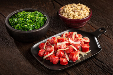 Sliced sausage with onion, green cabbage and farofa.