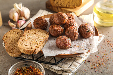 Plate with meat balls, baking paper, spices, bread slices and napkin on grunge background, closeup