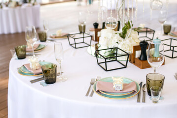 Round table in the restaurant during preparations for the reception of guests. Table setting and preparation for the banquet. Plates with gratitude and the inscription thank you
