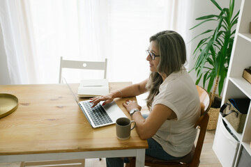 Adult woman working from home using her laptop