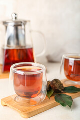 Board with glass of puer tea on white background, closeup