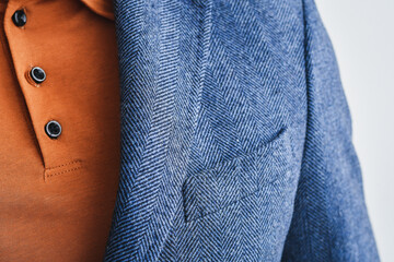 Fragment of blue tweed or woolen blazer combined with beige polo. Selective focus.