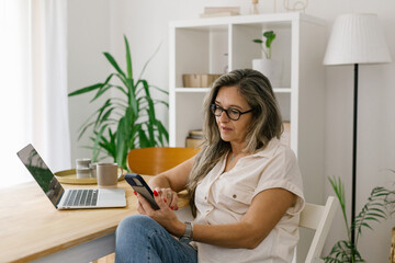 Woman sitting and using social media via cellphone