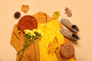 Stylish female clothes, bouquet of flowers and autumn leaves on beige background