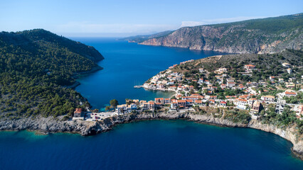 Naklejka premium Drone view to beautiful remote village in Greece, surrounded by crystal pacific blue and impressive cliffs on idyllic greek island in Ionian sea