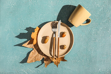 Autumn table setting with acorns and fallen leaves on grunge background © Pixel-Shot