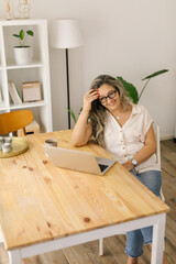 Smiling woman sitting and working from home via laptop