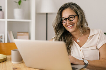 Happy woman having online meeting on laptop at home.