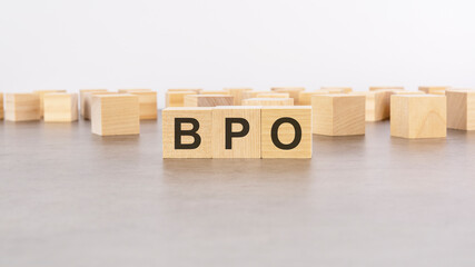 three wooden blocks with letters bpo - Business Process Outsourcing - with focus to the single cube in the foreground