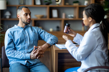 African american doctor showing black guy patient drugs