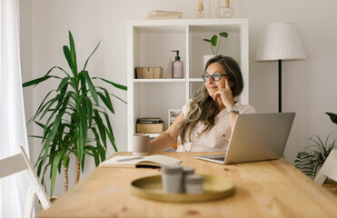 Wistful woman working remote from home office