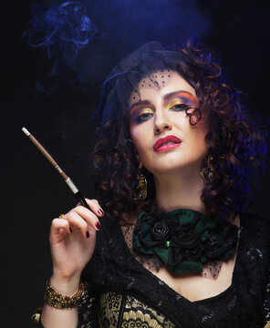 Beautiful adult woman in retro style holds a mouthpiece with a cigarette, smokes elegantly.