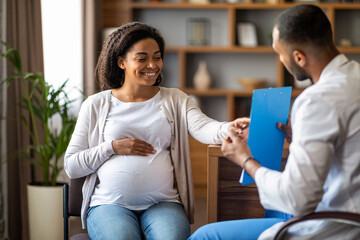 Pregnant african american woman visiting doctor at private clinic