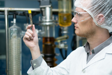 scientist in lab coat, researcher working in laboratory with cannabis oil CBD extraction machine,...