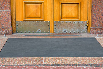 stone threshold with foot mat at the entrance door made of wood and granite stone facade cladding...
