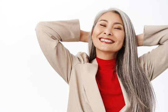 Portrait Of Healthy And Happy Asian Senior Woman, Middle Aged Korean Lady With Long Grey Hair, Laughing And Smiling, White Perfect Teeth, Studio Background