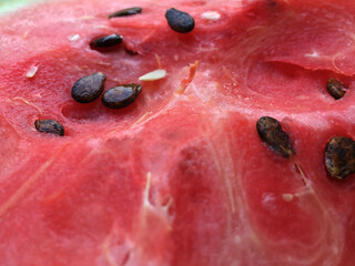 Juicy pulp of watermelon is red, scarlet in color, with a beautiful surface texture with seeds.