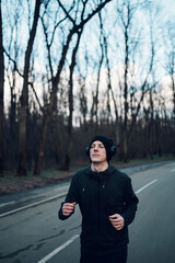 Redhead young man running outside on a mountain road